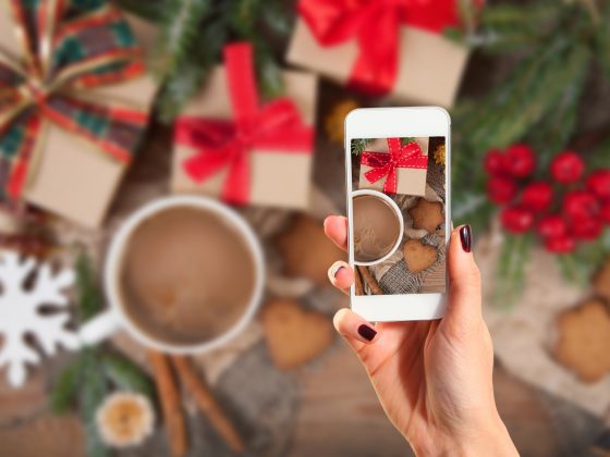 Hands taking picture of gingerbread cookies with smartphone